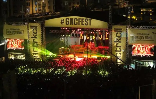 Yeşil lazer ışıklarıyla aydınlatılmış #GNCFEST ana sahnesi ve kalabalık