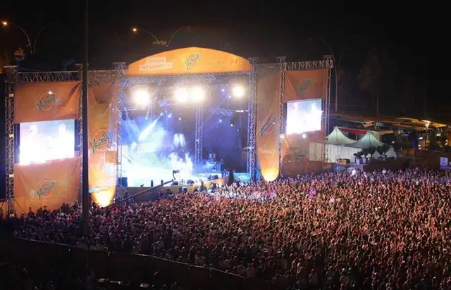 Turuncu tasarımlı sahnede canlı konser ve geniş izleyici kitlesi