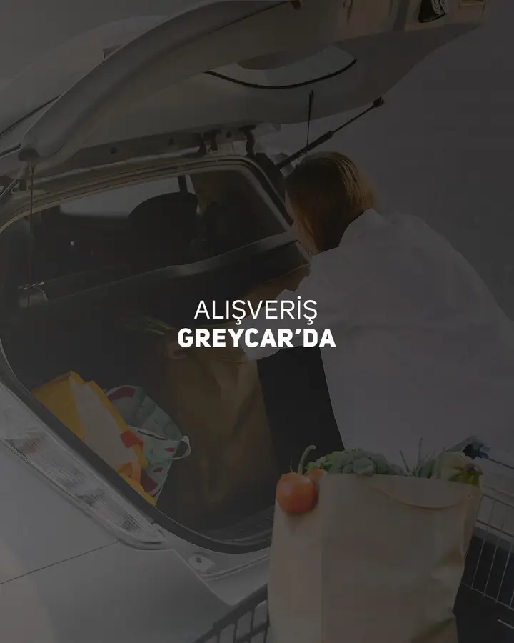 Aracın bagajına market poşetlerini yerleştiren kişi; üzerinde “Alışveriş GREYCAR’da” yazıyor
