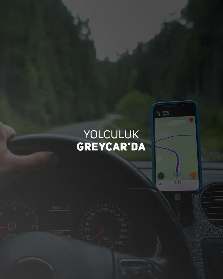 Direksiyonda orman yolunda yol tarifi gösteren telefon; üzerinde “Yolculuk GREYCAR’da” yazıyor